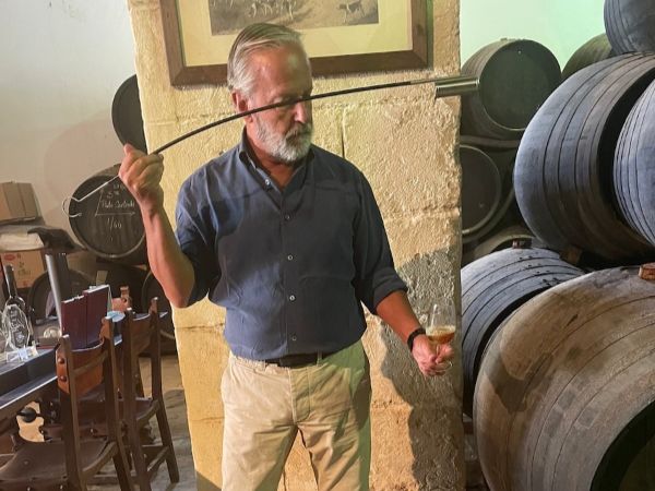 man serving sherry with a venencia in a sherry bodega in Jerez