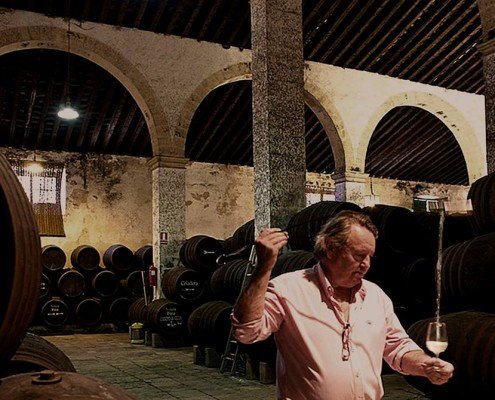 man pouring sherry from the barrel